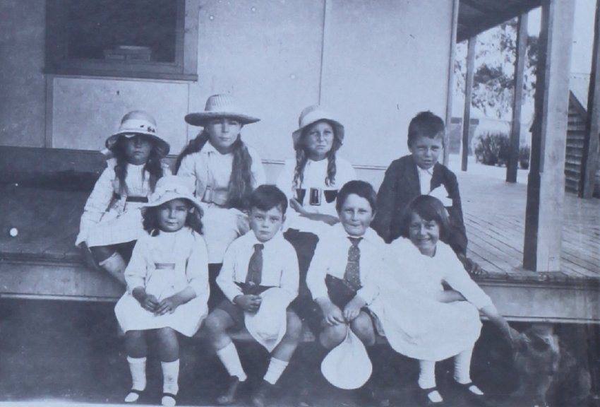 Group of children sitting on the verandah steps