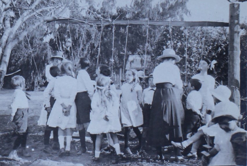 Group of children trying to eat apples on strings