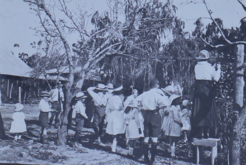 Group of children trying to eat apples on strings