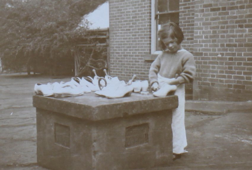 Young girl cleaning shoes