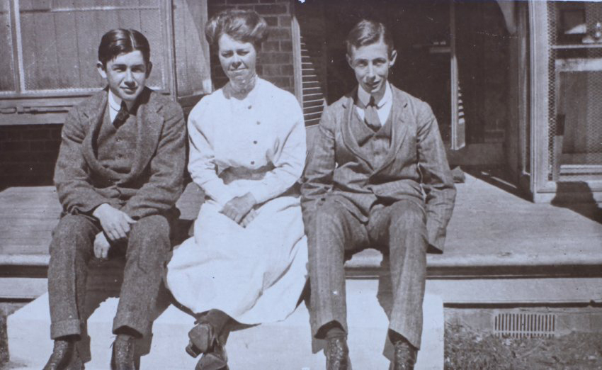 Two young men and a woman sitting on verandah steps
