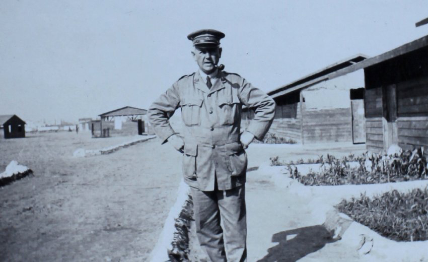 Officer on the path outside timber huts