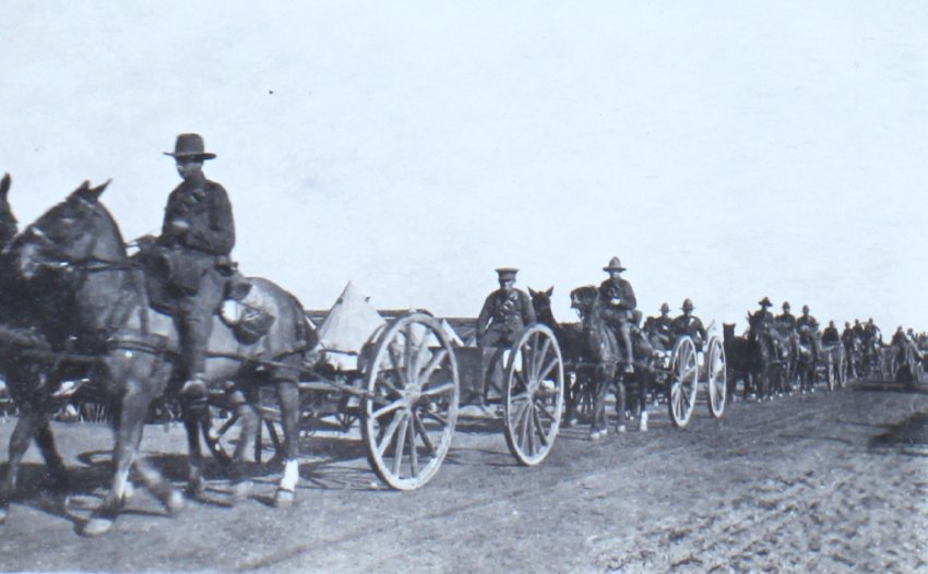 Soldiers on horseback pulling gun carriages