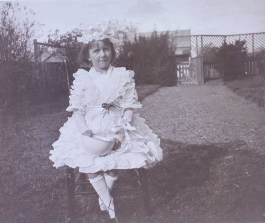 Girl sitting in the garden with bowl and spider
