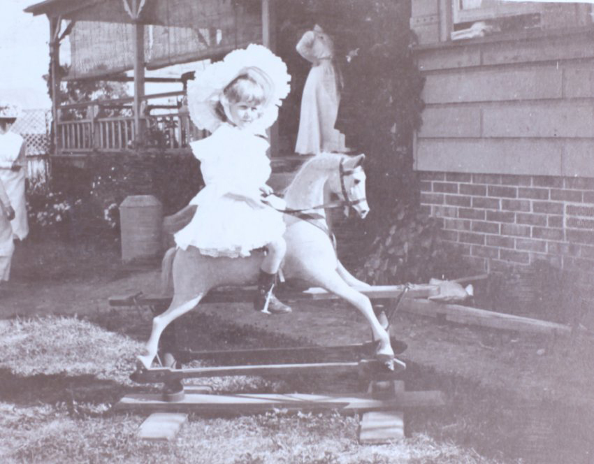Young girl riding a rocking horse