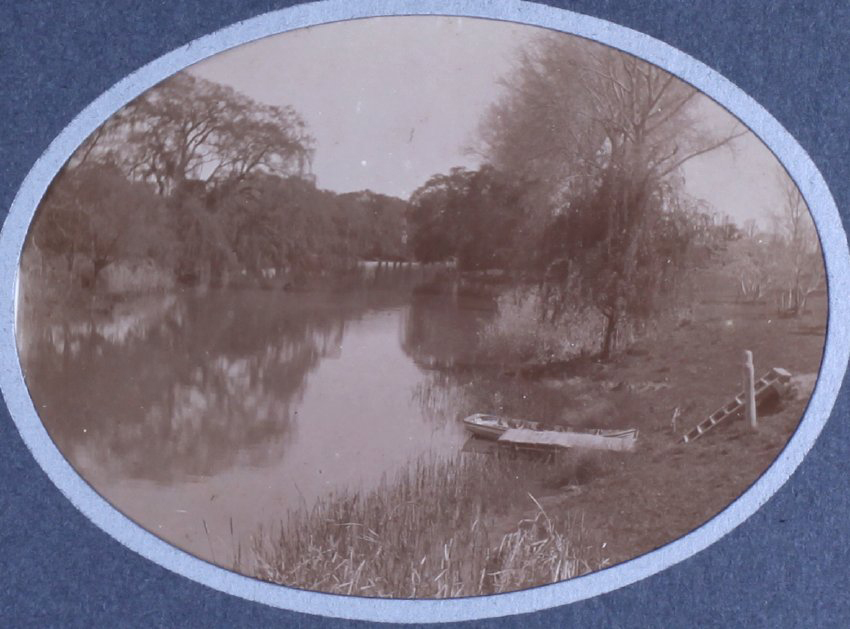 View of a river with a small boat at the edge and steps down the bank to the boat