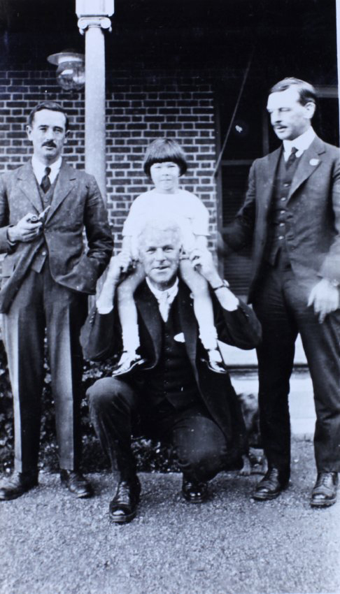 Three men and a girl standing in front of a house