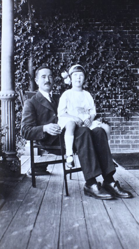 Man sitting on the verandah with a girl sitting on his lap