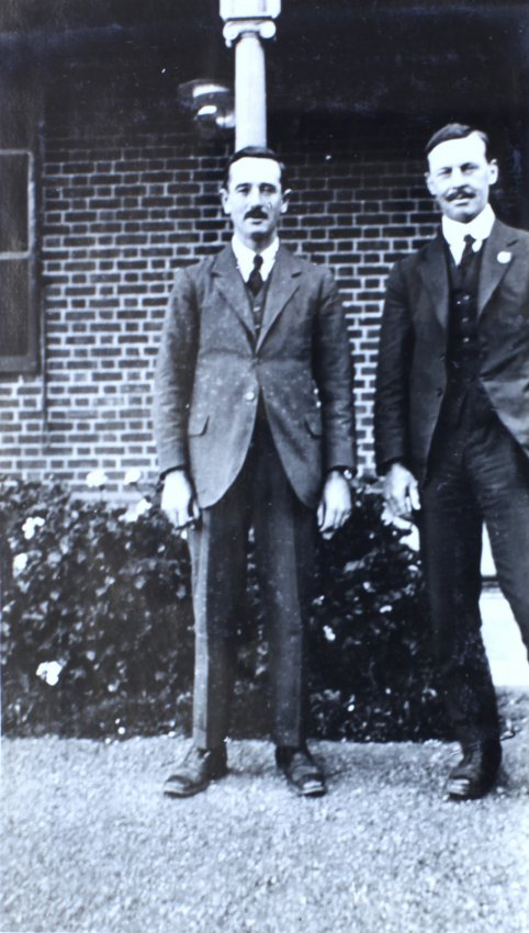 Two men standing in front of a house