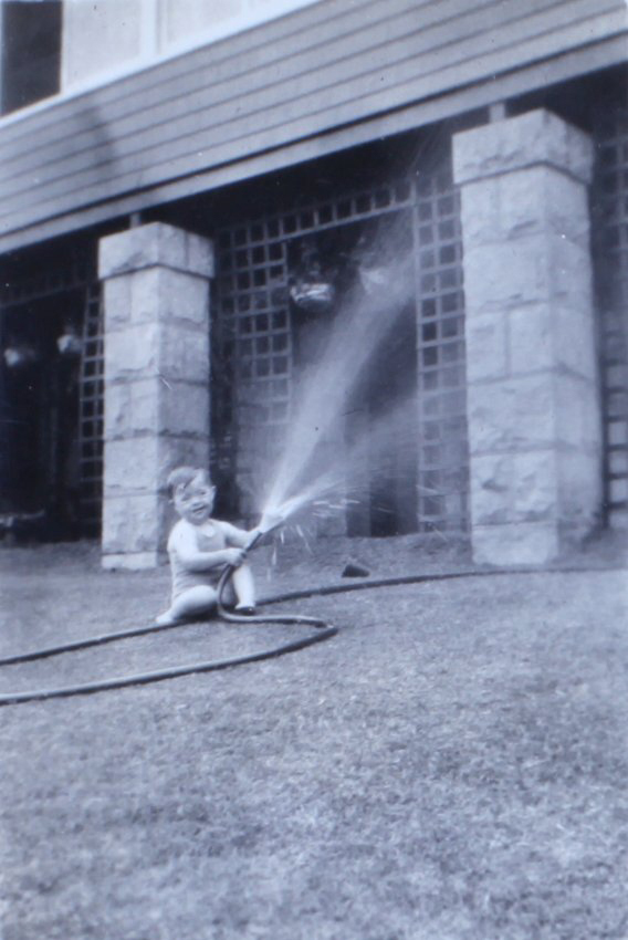 Jill playing with a water hose on the lawn