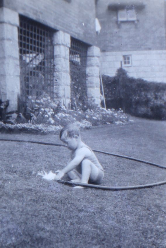 Jill playing with a water hose on the lawn