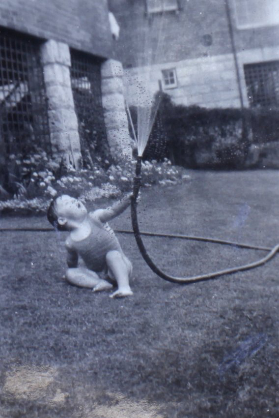 Jill playing with a water hose on the lawn