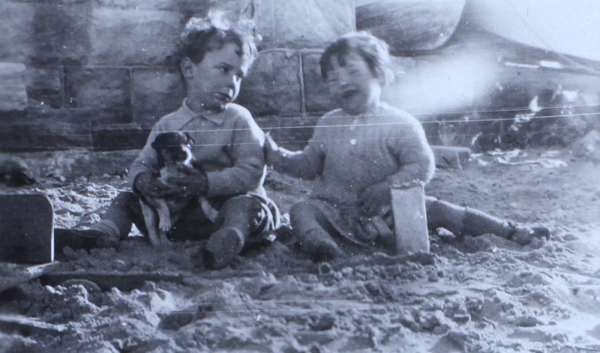 Jill on the beach with another child and pet puppy