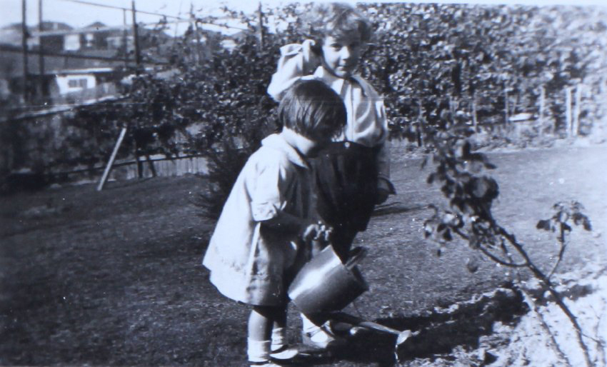 Jill with another child watering the garden