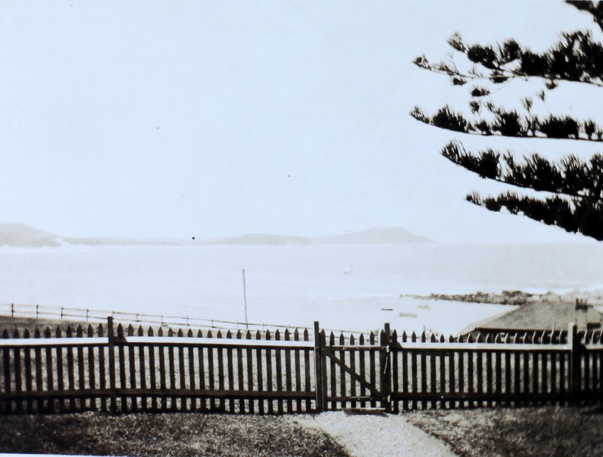View of beach beyond a picket fence