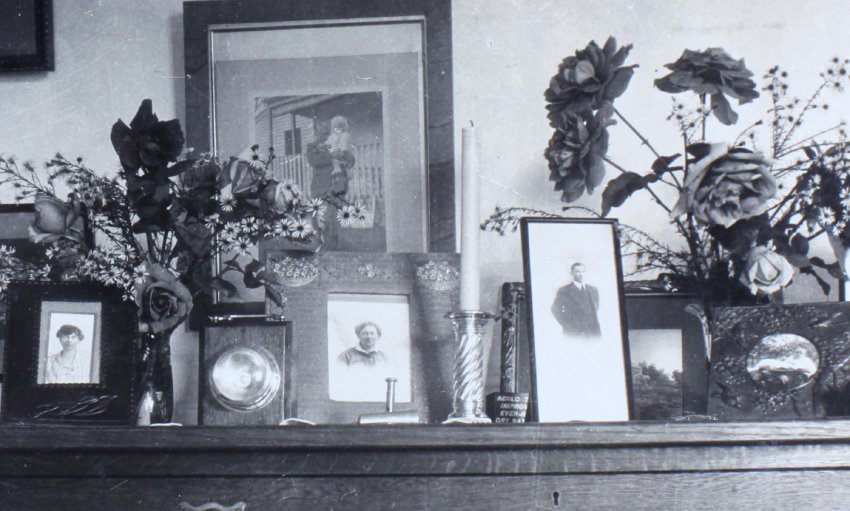Top of a cabinet with photographs and flowers
