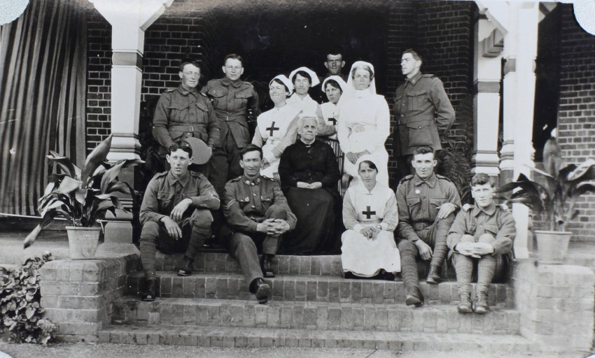 Group of soldiers and nurses sitting on the steps of Saumarez