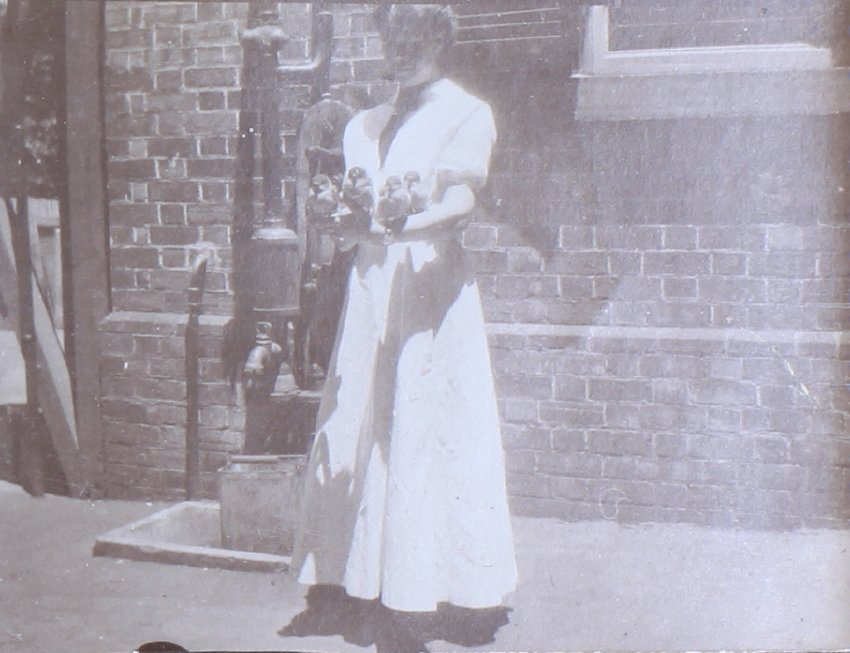 Undentified woman with four birds roosting on her arm
