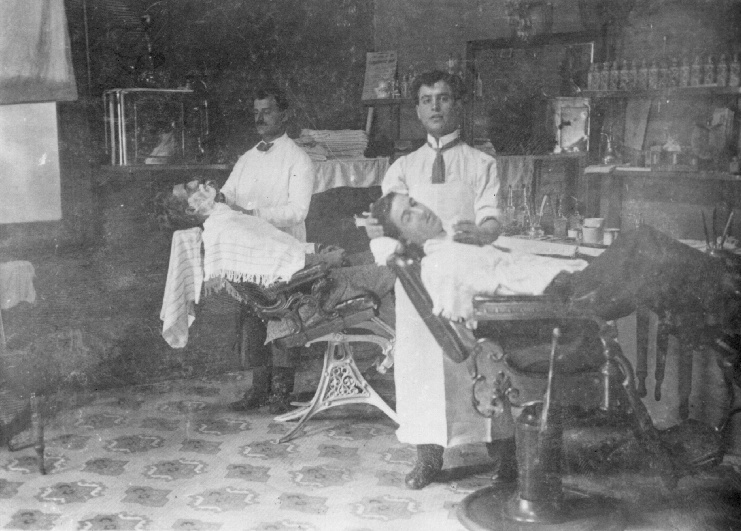 Joe Correy inside his barber shop in Glen Innes, about 1908