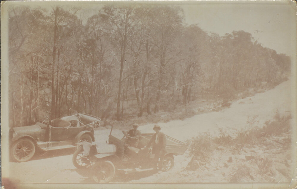 Car and utility stopped on mountain road
