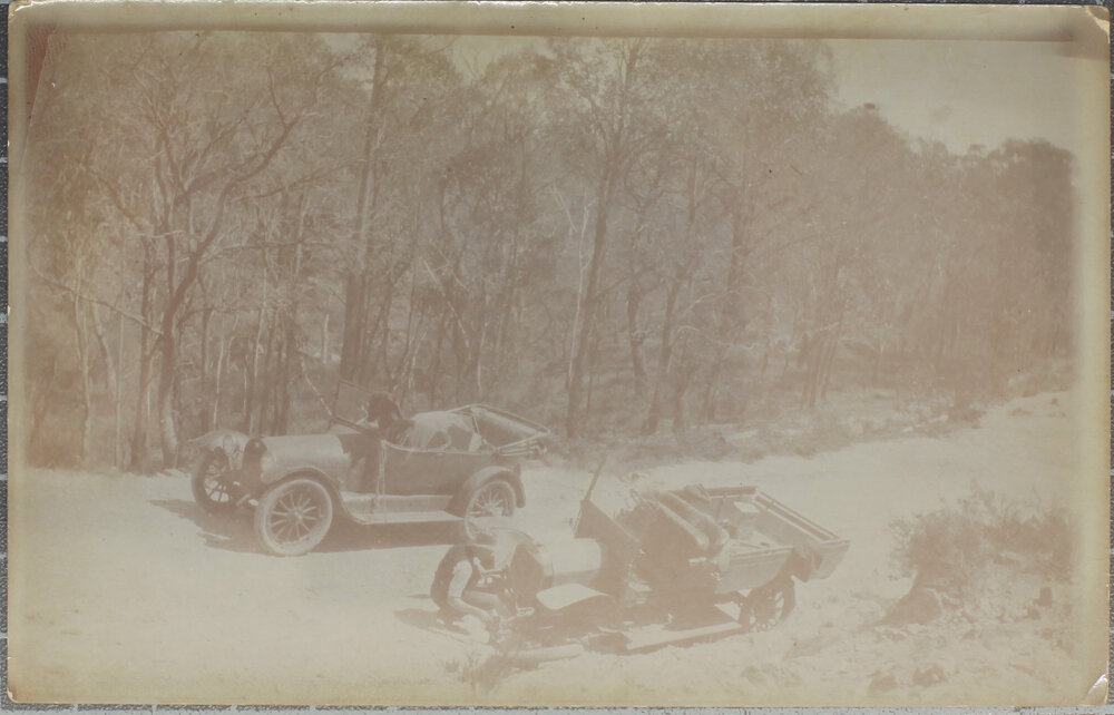 Car and utility stopped on mountain road, wheel change