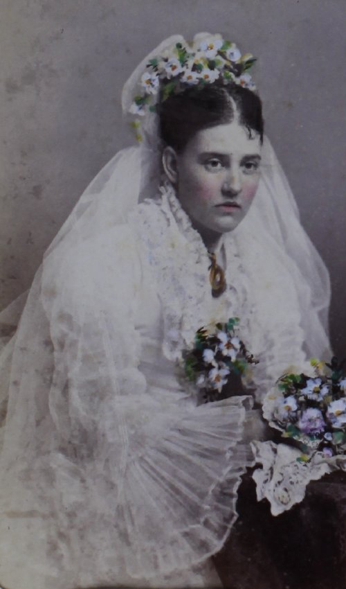A tinted carte-de-visite of a woman in bridal dress