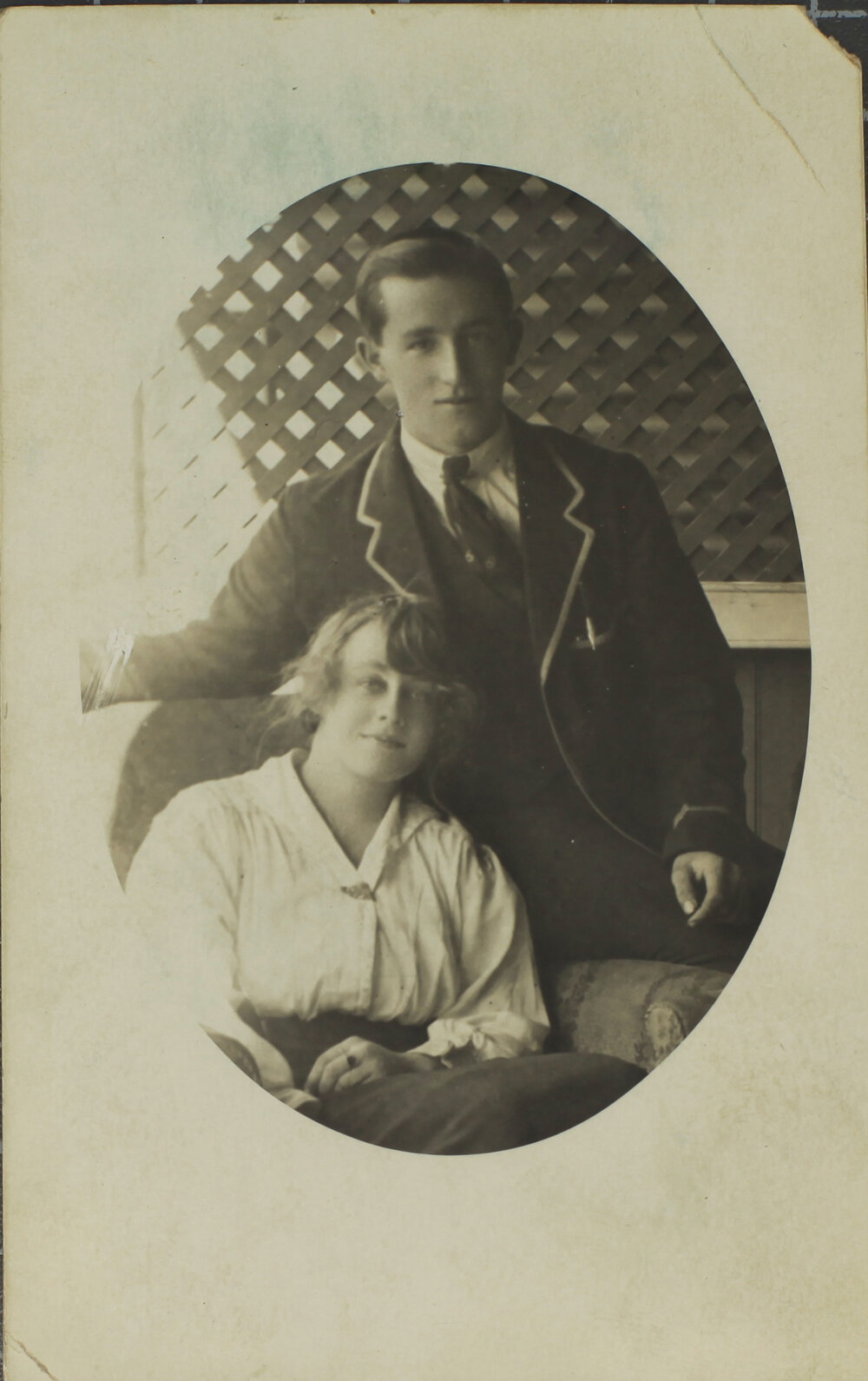 Boy in blazer and girl seated in loungechair