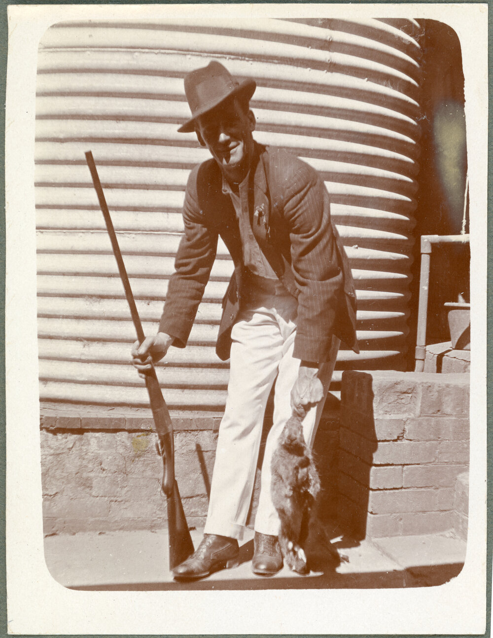 Man holding rifle and rabbit