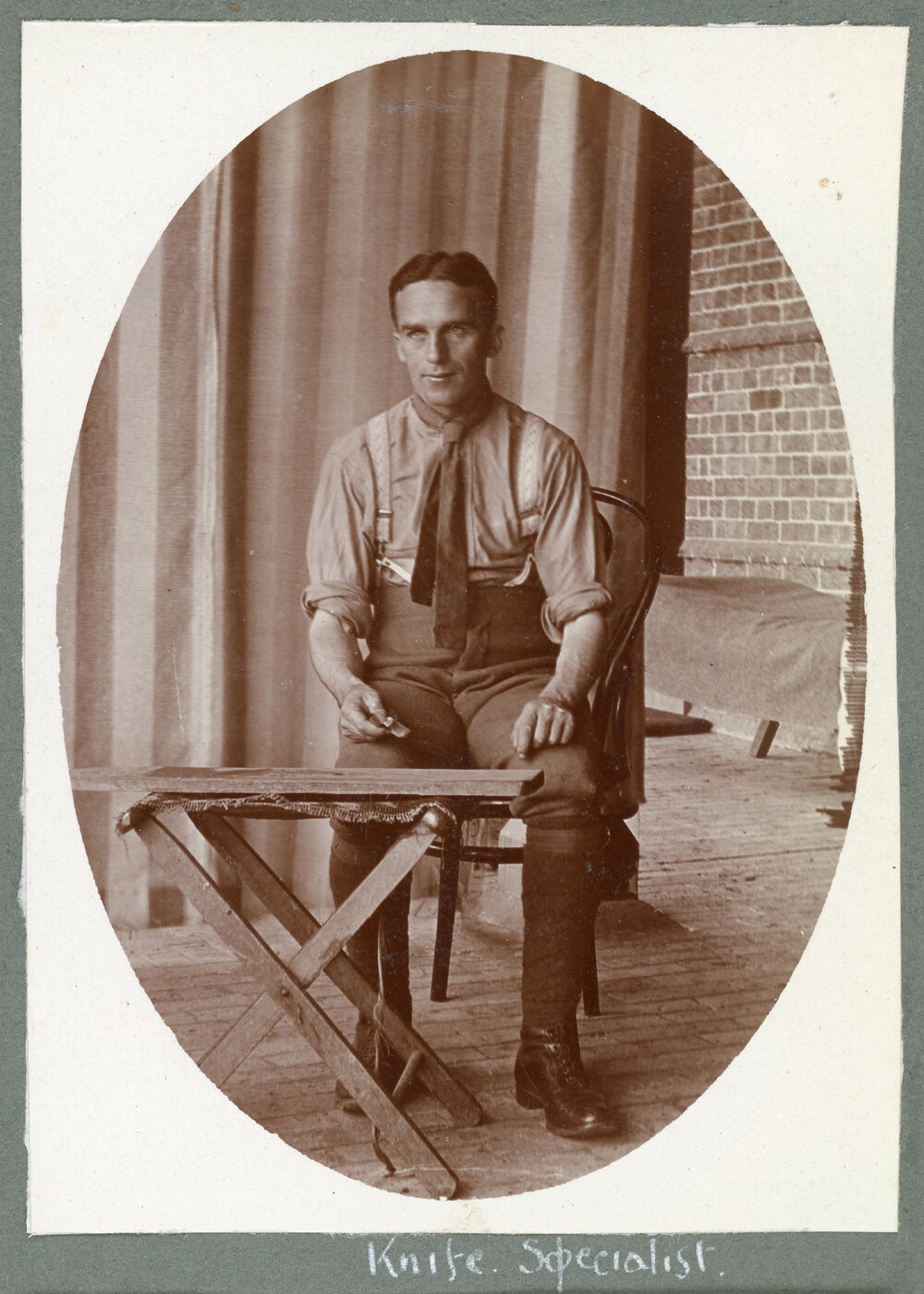 Seated man with knife at work bench