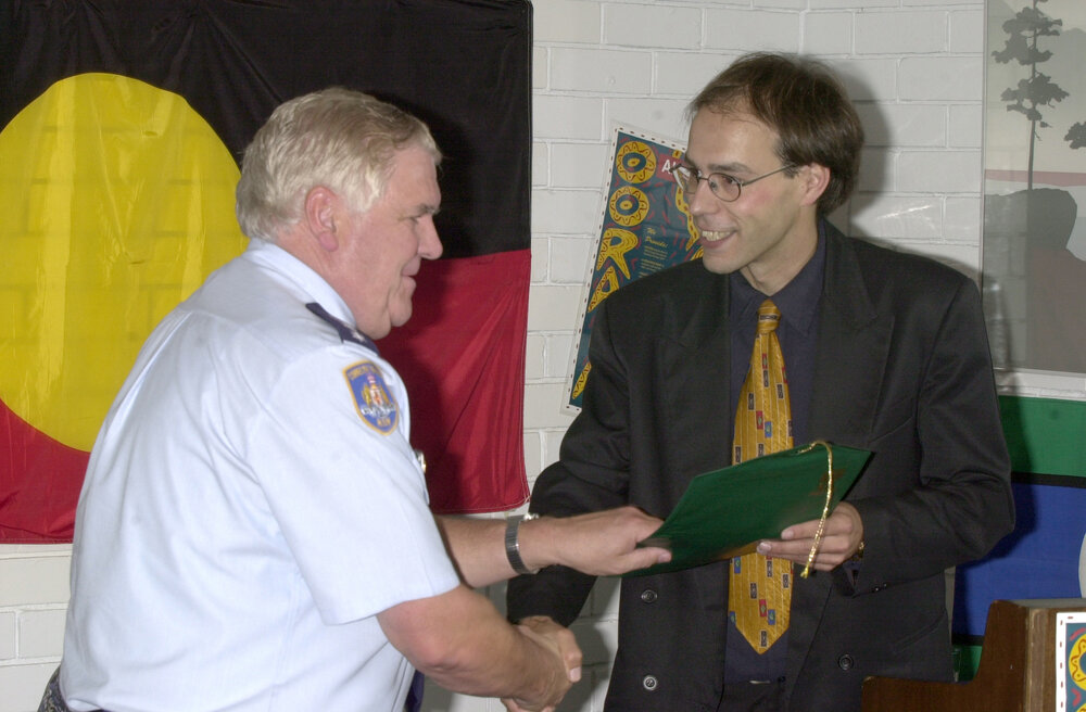 Governor of the Glenn Innes Correctional Centre, Hank Zwiers, receives award from Guido Posthausen of UNE's Oorala Centre