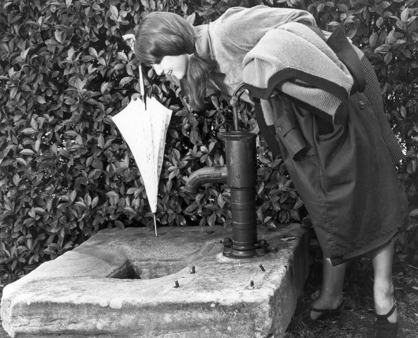 Student viewing water pump in the grounds of the Education Museum, c. 1975