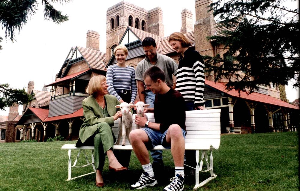 Professor Ingrid Moses with lambs and students, UNE, 1999