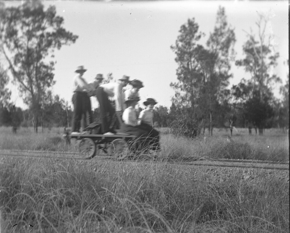 Group of six riding a hand-operated railway trolley