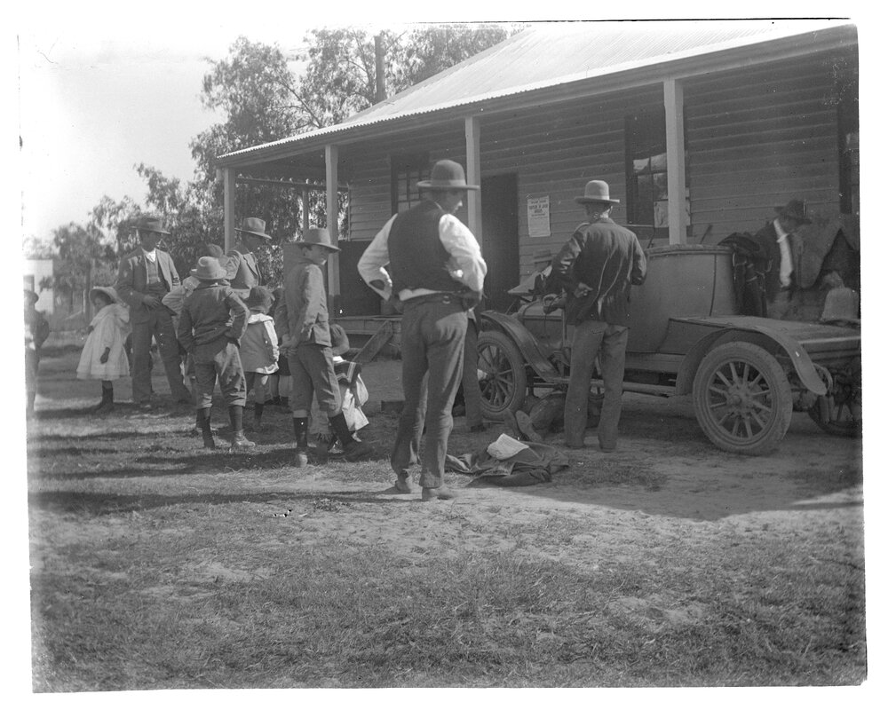Group standing beside a motorcar