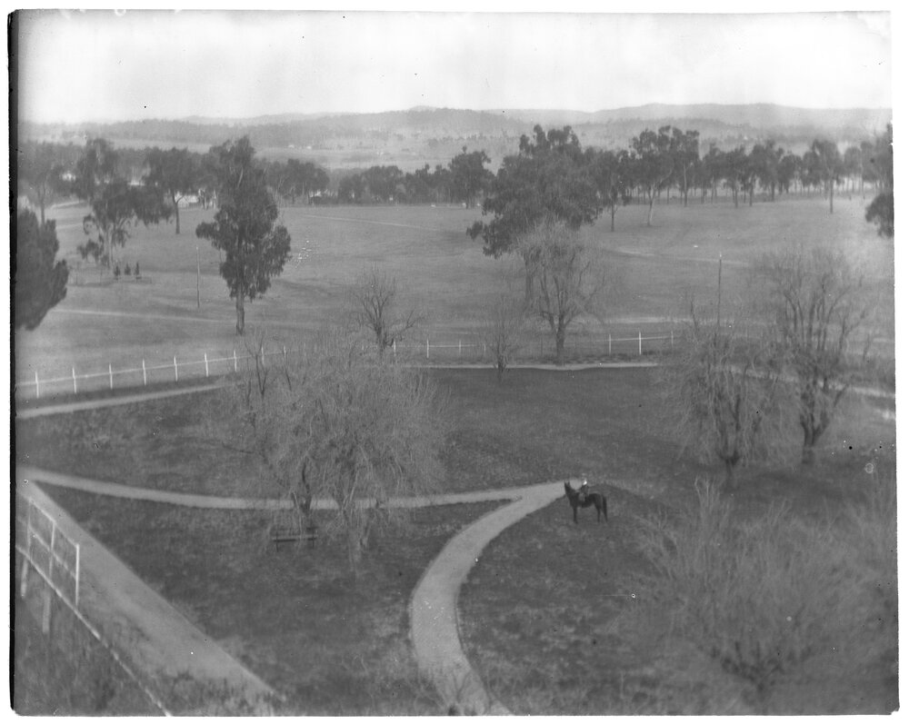 Elevated view of a paddock with a person riding a horse