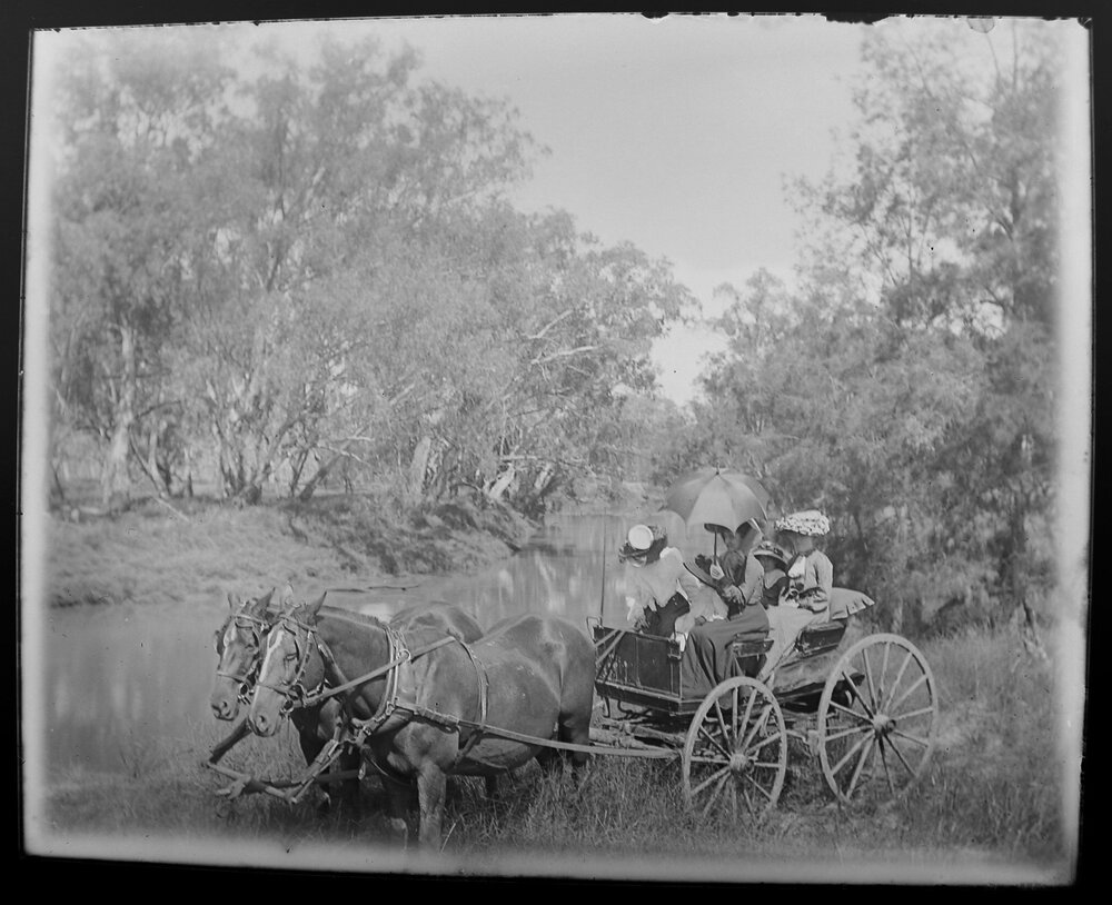 Family in horse drawn wagon by a watercourse, 1905