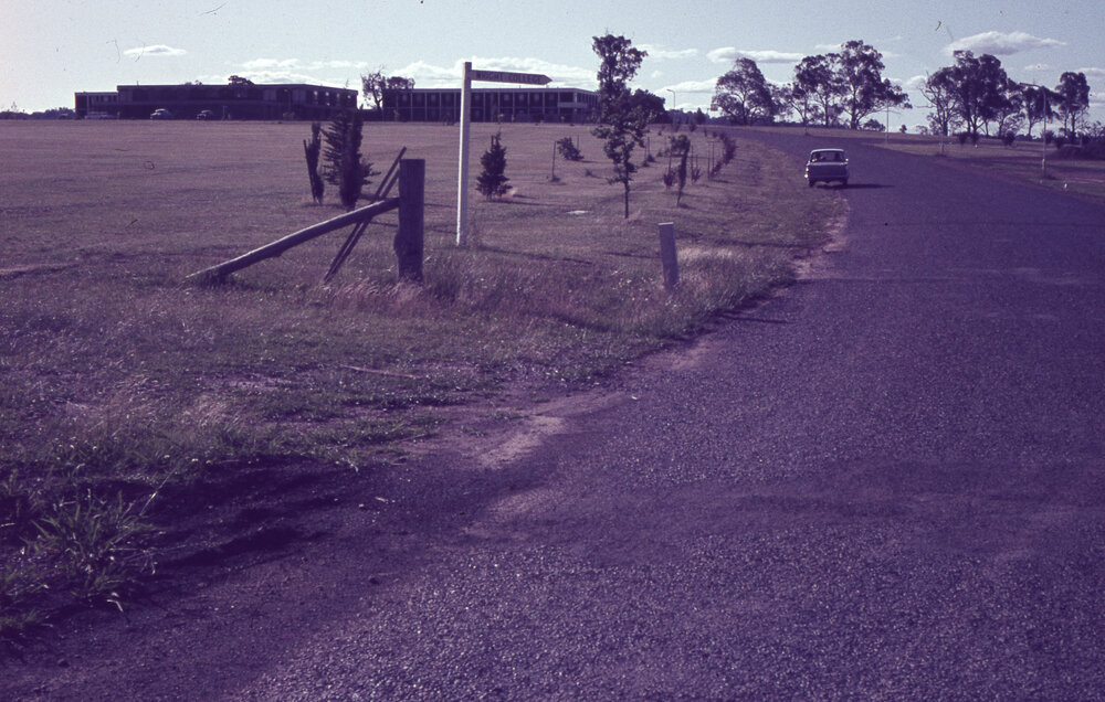 Road with signpost pointing to Wright College, UNE