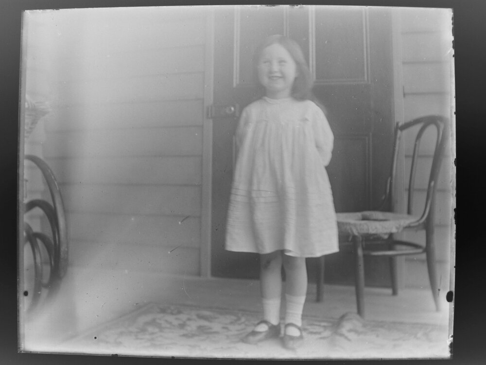 Smiling girl standing in front of a door