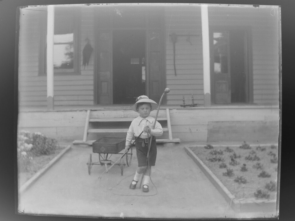 Boy pulling a wagon down garden path