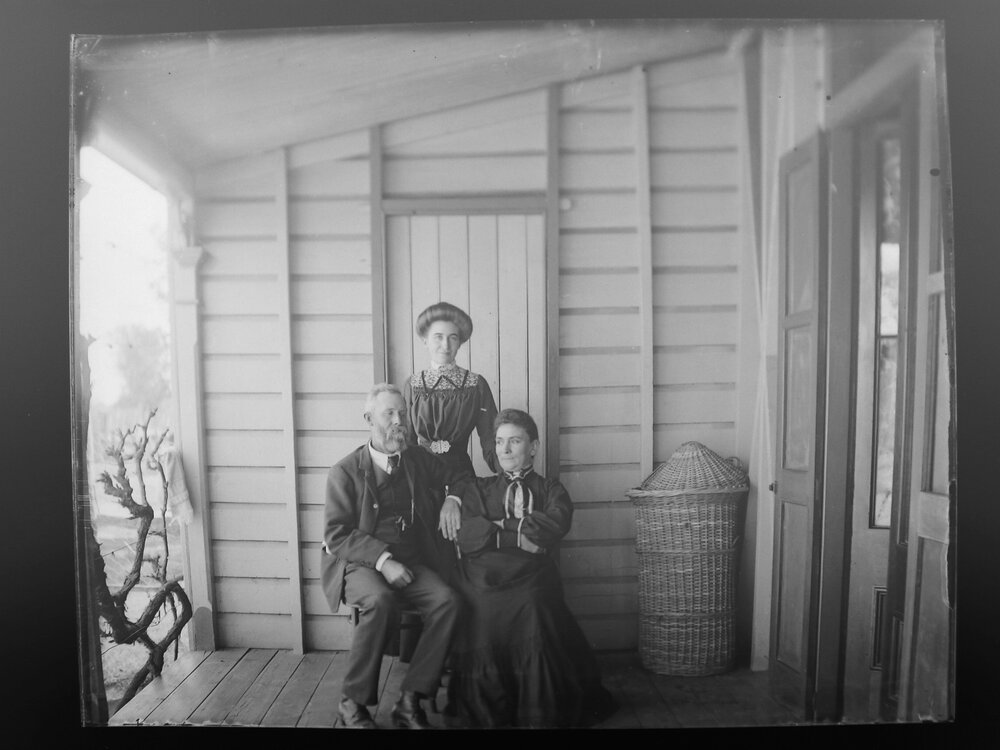 Mr, Mrs, and Miss Gunns stand on a verandah