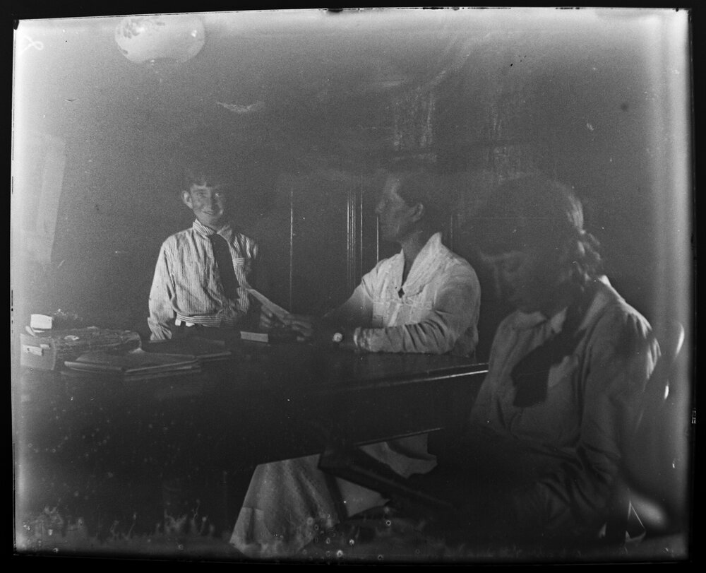 Two women and a boy at a desk with books