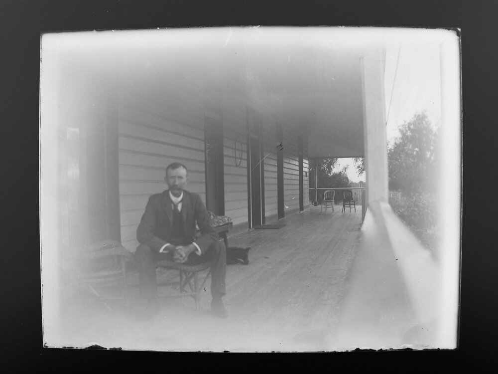 D. M. Cameron sitting on a verandah