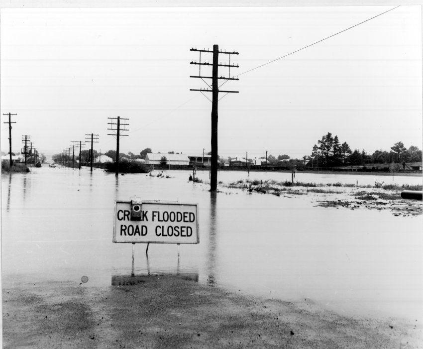 Flooded creek, looking west along Beardy Street from Jessie Street intersection, 1970