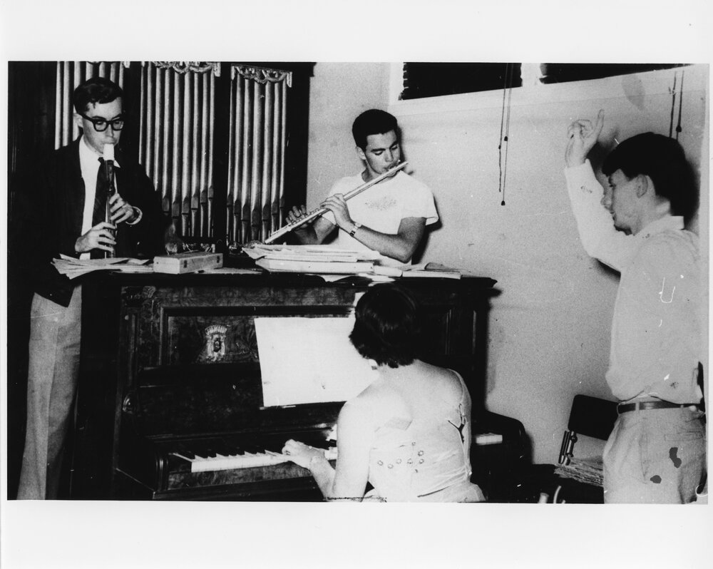 Three musicians playing piano, flute and clarinet with a conductor