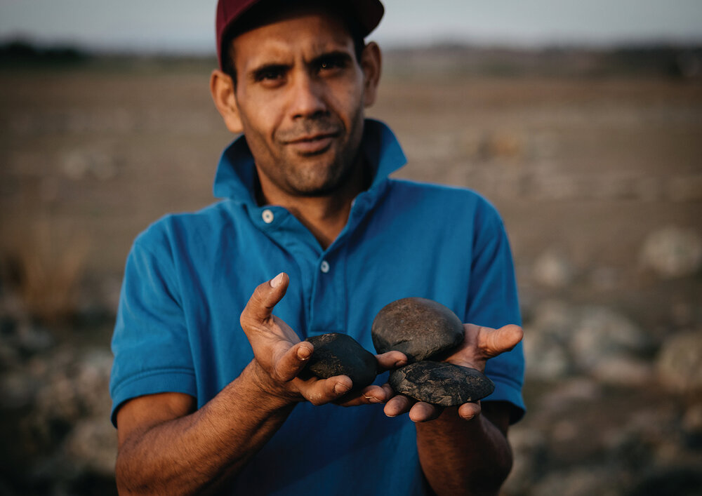 Colin Ahoy, UNE Archaeology student with local axe heads at the Gostwyck Grinding Grooves site, 2022