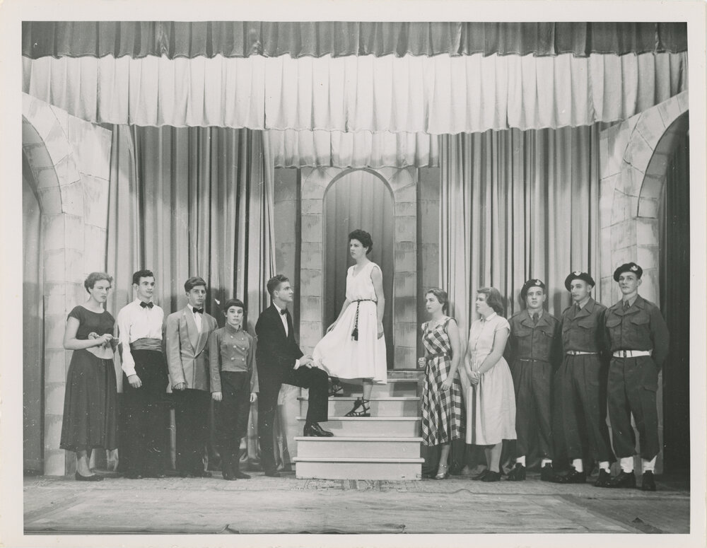Cast of students on a theatre set