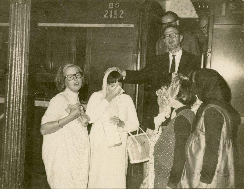 Wright College students performing a farewell scene at a train, with John Ryan in the carriage doorway