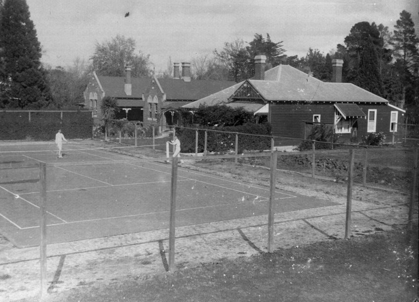 Photo of unidentified tennis court and houses