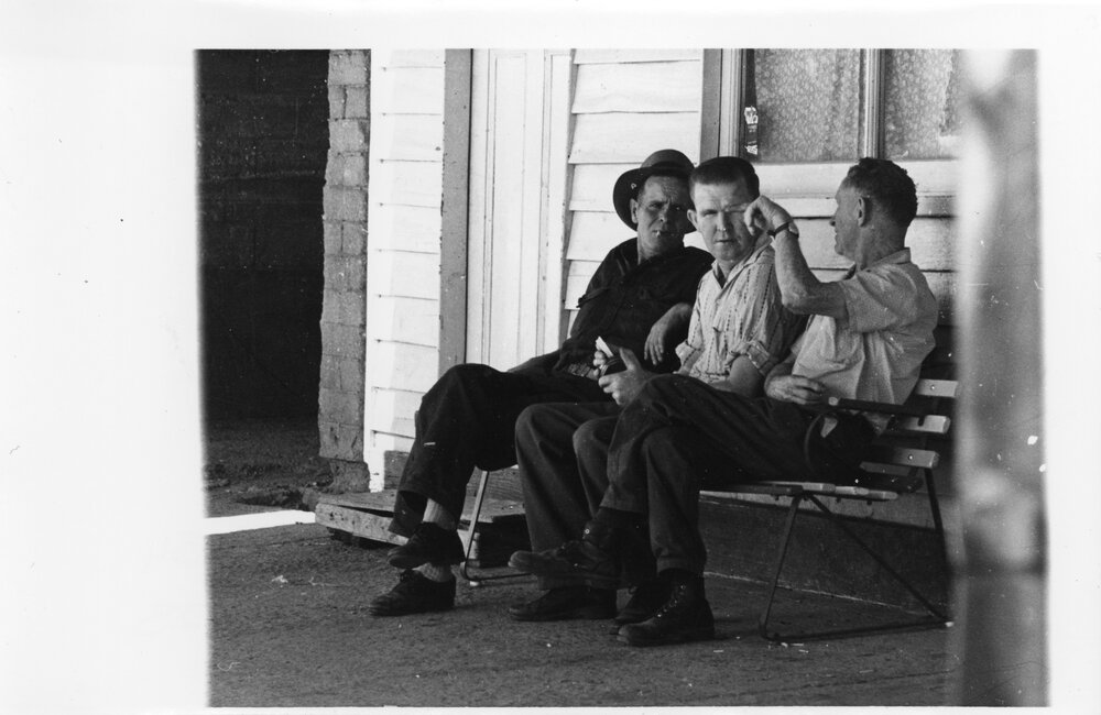 Three unidentified men on a seat