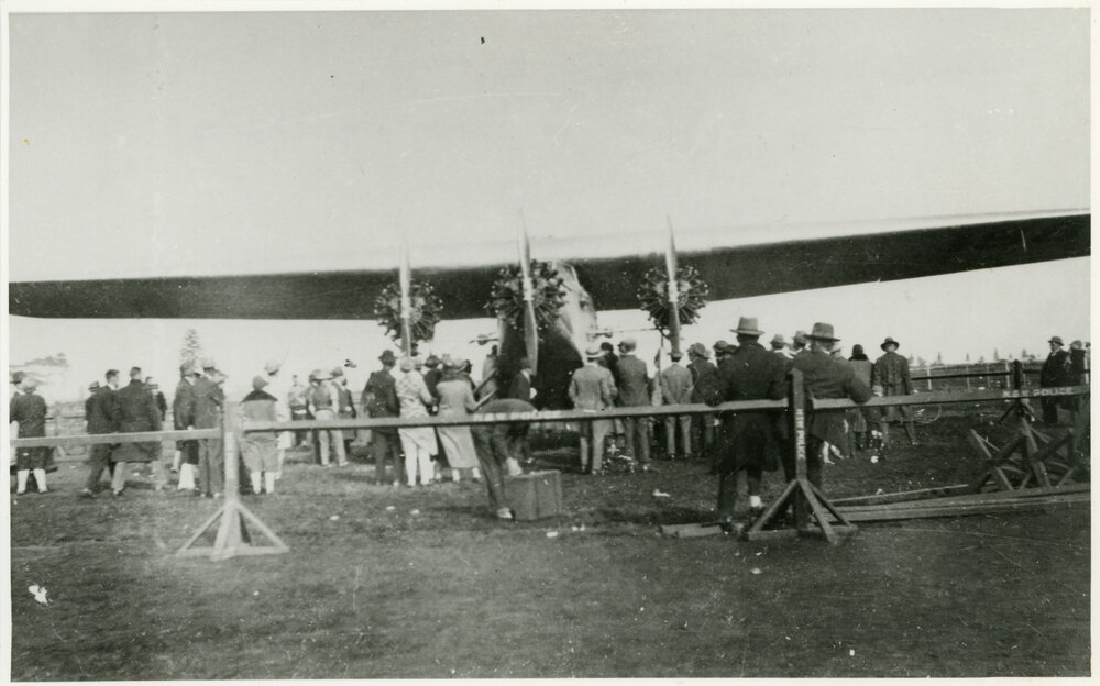 Ford Trimotor or Fokker aircraft and crowd